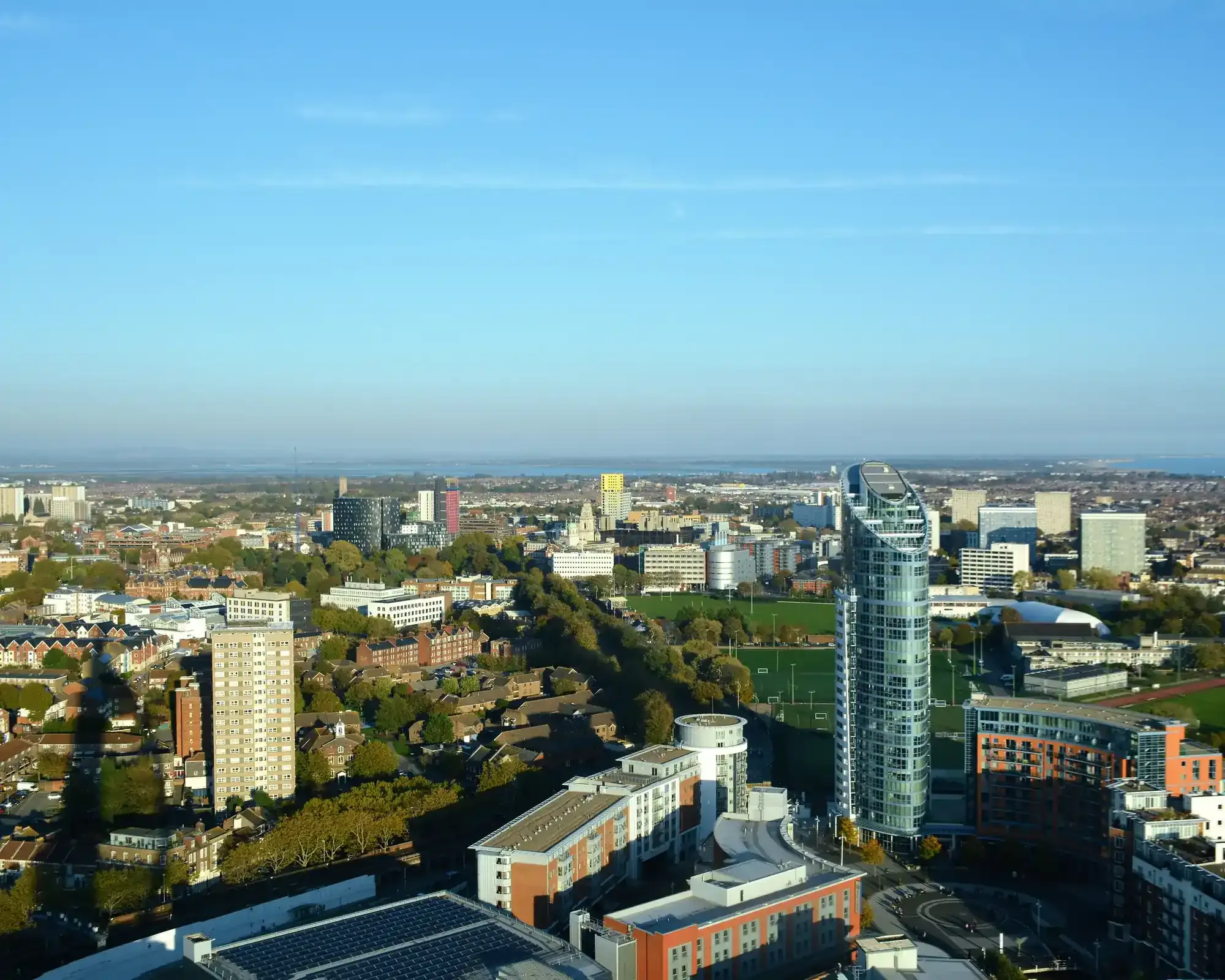 Aerial view of Portsmouth city centre skyline, featuring residential tower blocks and green spaces
