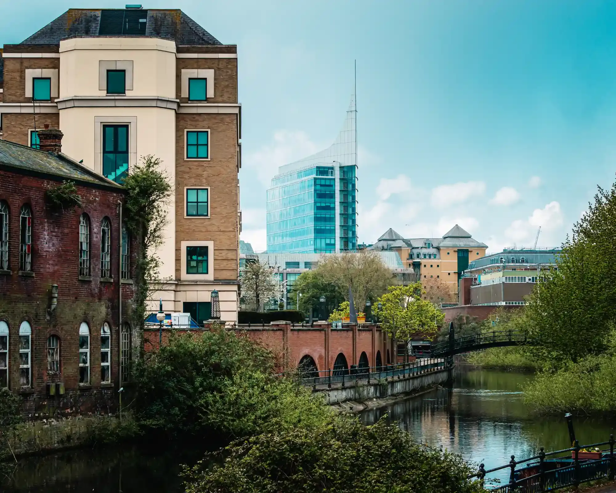 The River Kennet in Reading town centre, with an old brick building, a footbridge and The Blade office tower on the skyline.