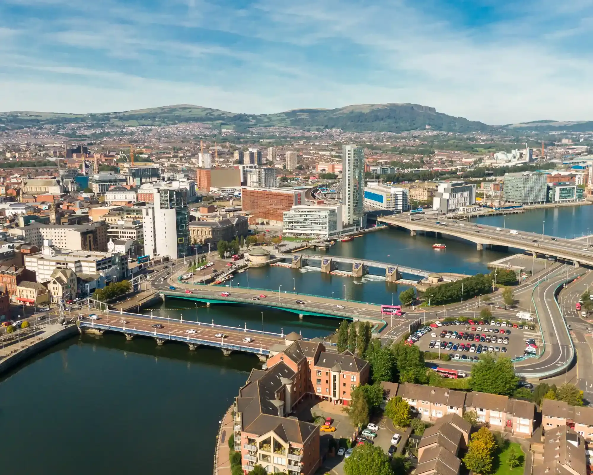 Aerial view of the River Lagan in Belfast, with the Lagan Weir, the city centre and Cave Hill beyond.
