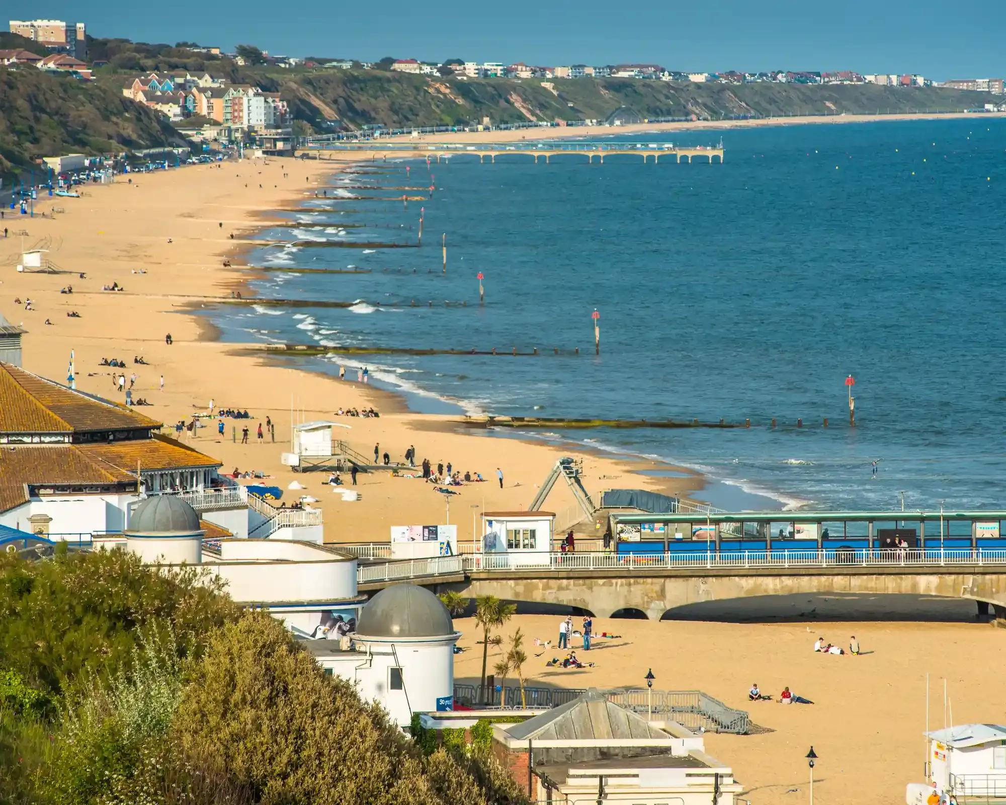 Bournemouth Pier and the long sandy beach, with Boscombe Pier and clifftop homes stretching along the coast.