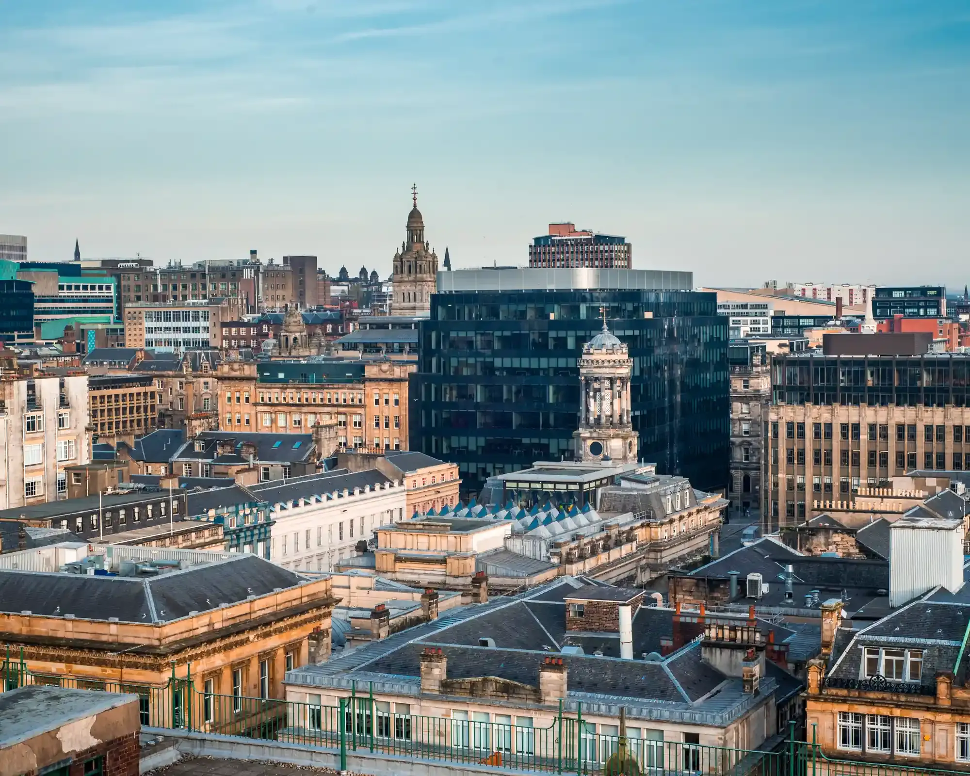 Sandstone rooftops in Glasgow city centre, with the City Chambers tower rising in the distance.